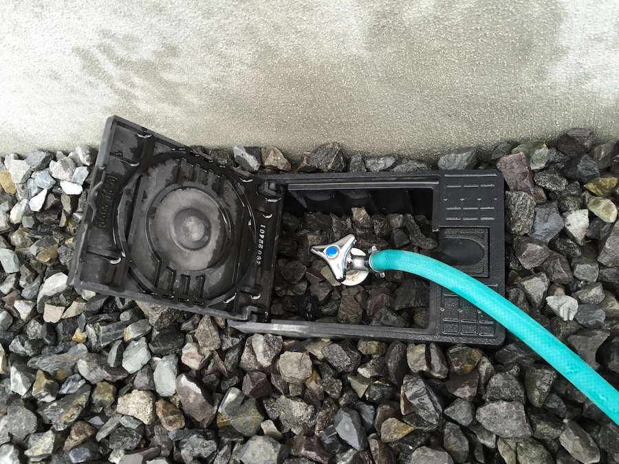 散水栓にホースをつないで使用するイメージ画像。