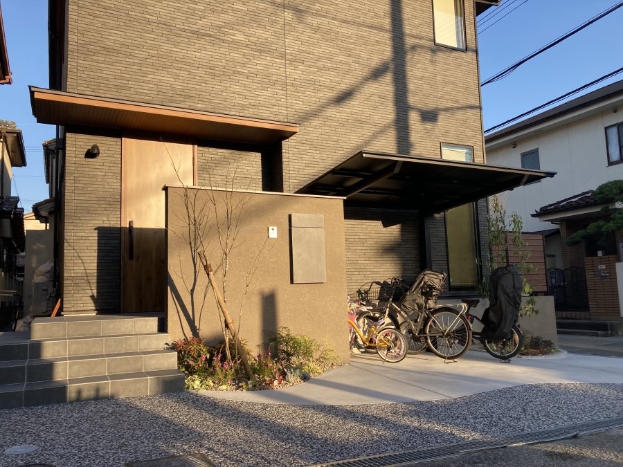 玄関まわりに設置された自転車置き場の施工事例。屋根（サイクルポート）付きで、雨の日も子乗せ自転車の乗り降りがラクに。