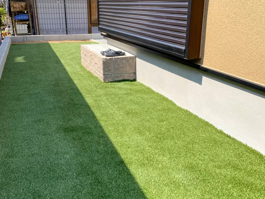木製ドアと丸窓が映えるブラウン外壁の新築外構