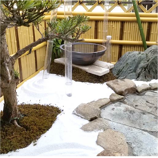 ソトリエ広島西の造園施工実績4、和テイストのお庭。アクリルの竹筒などモダンな雰囲気も取り入れつつ、白い砂で雪の風情も感じさせます。