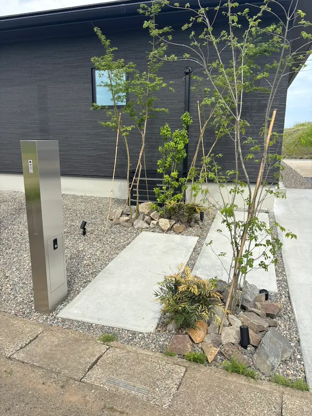 SOTORIE埼玉鶴ヶ島のエクステリア施工実績3、スタイリッシュなシルバーの機能門柱と割栗石、シンボルツリーを配したドライガーデン風の外構