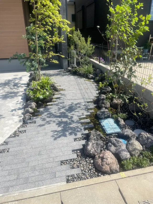 SOTORIE埼玉鶴ヶ島のエクステリア施工実績4、自然石の縁取りと石畳のアプローチ、雑木風の植栽が美しい小道